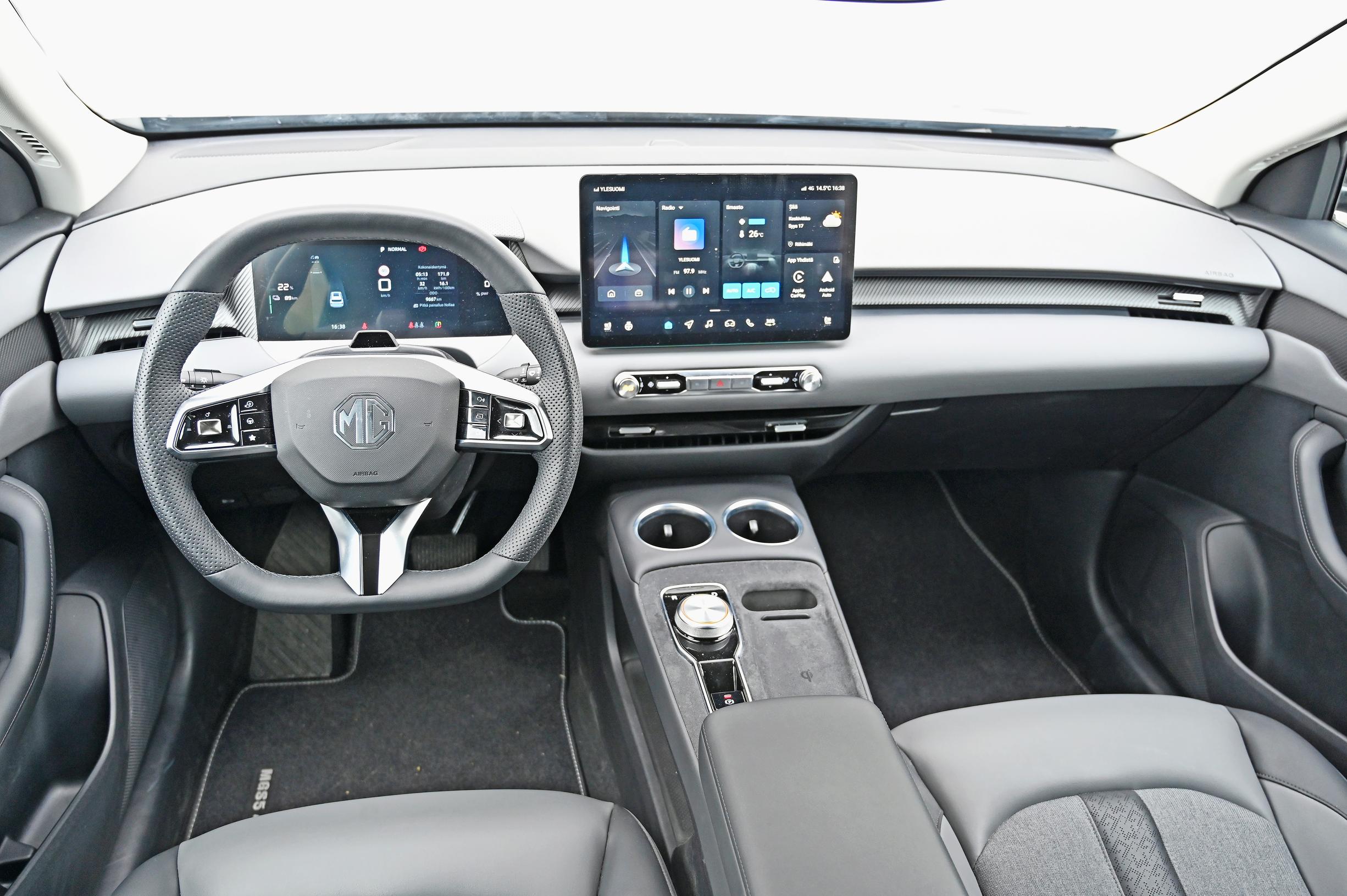 MG S5 EV Luxuryn ohjaamon pehmeät pinnat ja kaksiväriset harmaat nahkajäljitelmäistuimet tavoittelevat premium-tunnelmaa, jota ei synny. 