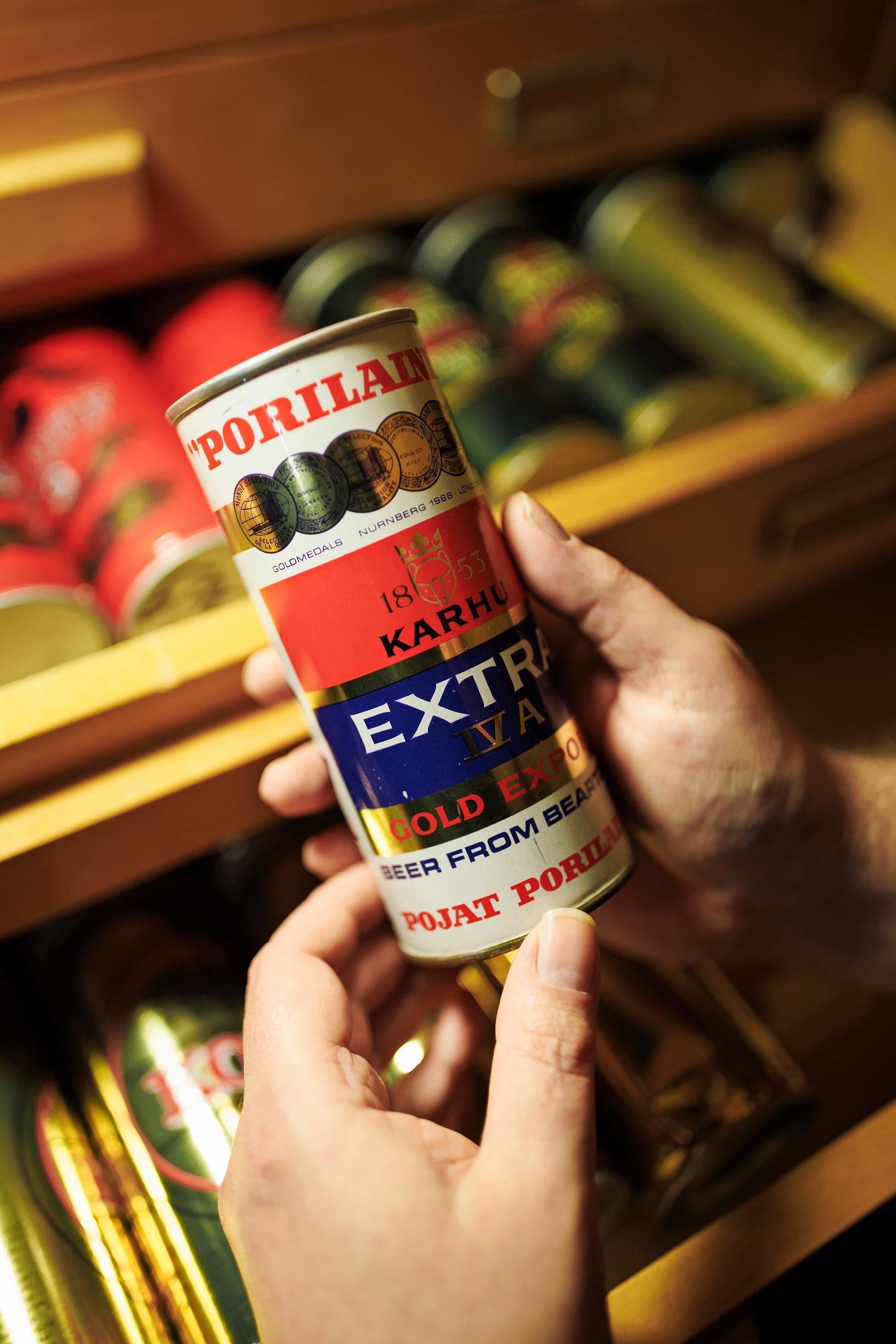 Lähikuva käsistä pitämässä vanhaa oluttölkkiä.