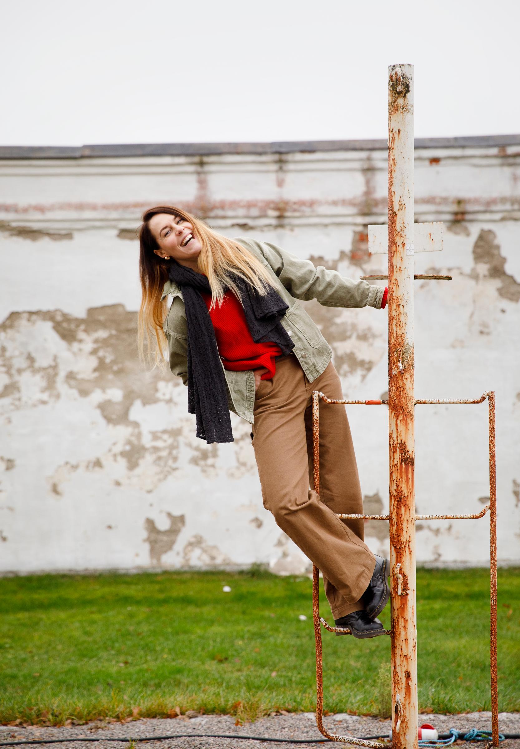 Noora Toivo kiipeää telineeseen ja hymyilee