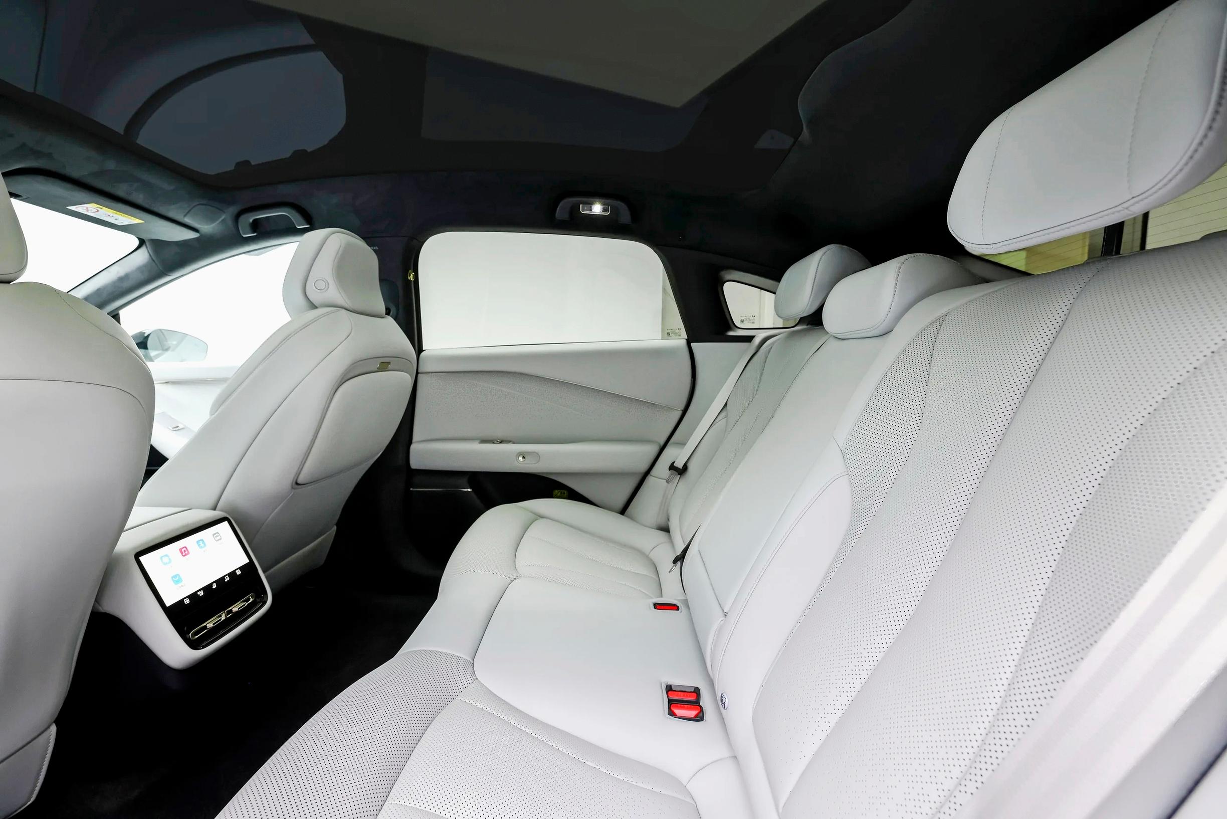 Xpeng P7+:n yli kolmen metrin akseliväli tuo takapenkille reilusti polvitilaa, ja matkustusmukavuutta lisäävät lentokonepöydät – viistosti laskeva kattolinja syö hieman pääntilaa.