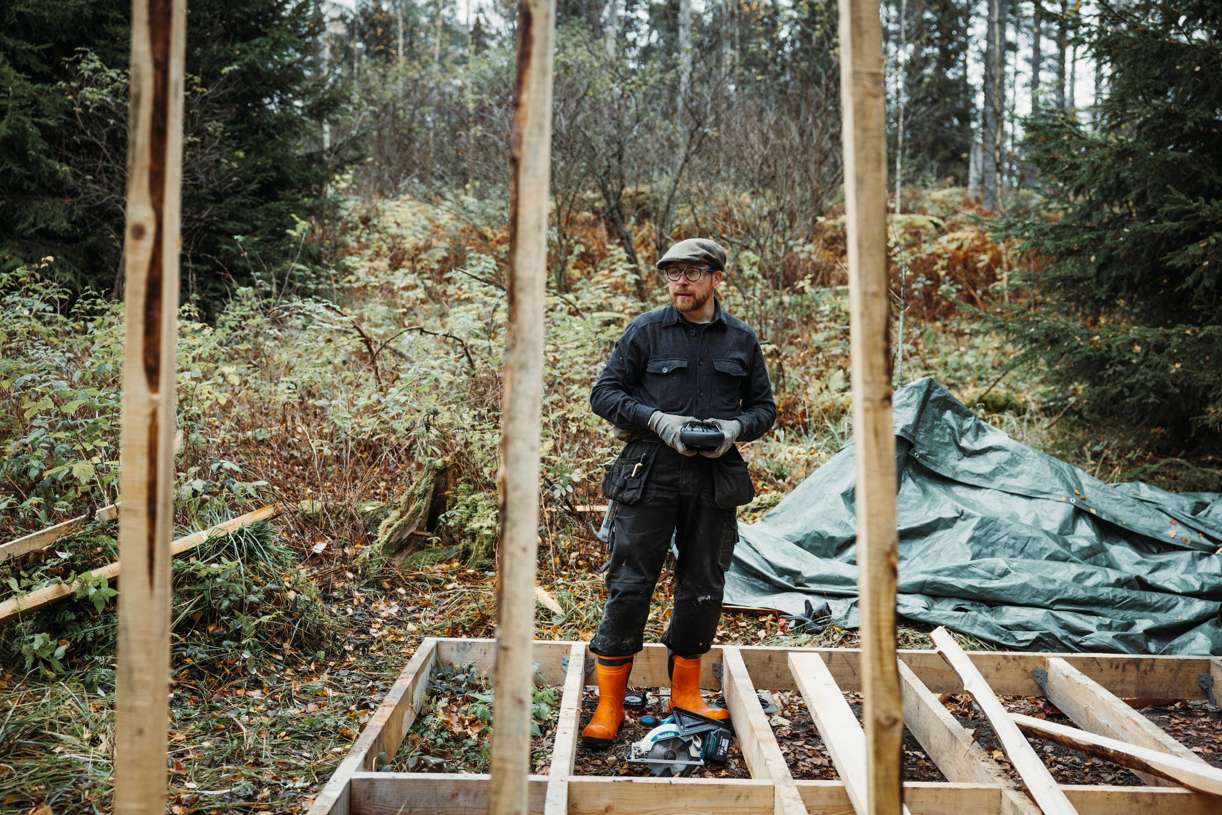 Valtteri Lindholm seisoo keskeneräisen työkaluvajan äärellä. Seinätolpat on jo saatu pystyyn.