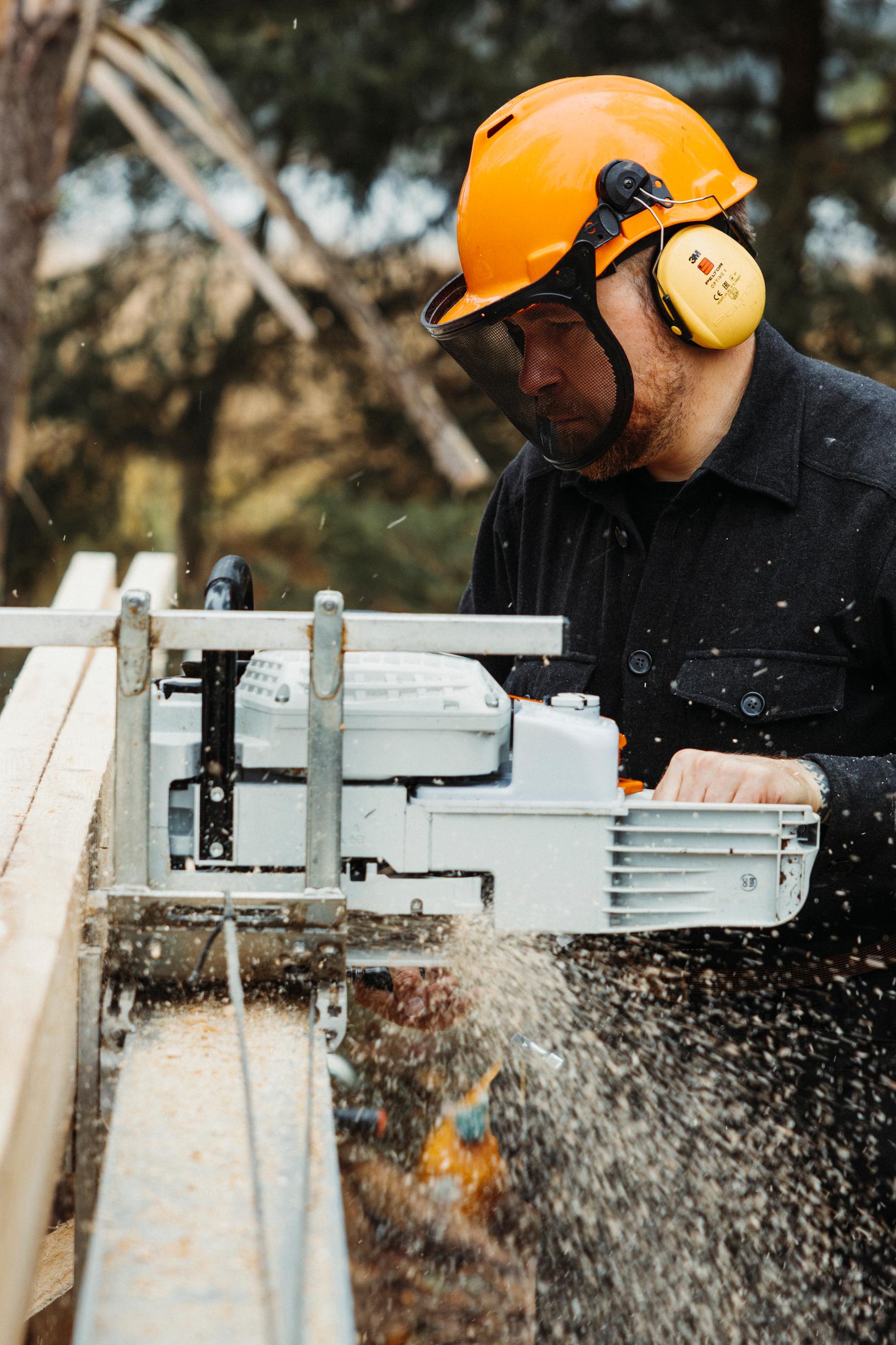 Valtteri Lindholm sahaa tukeista lankkuja omassa ­sahalaitoksessaan, omassa saaressaan.