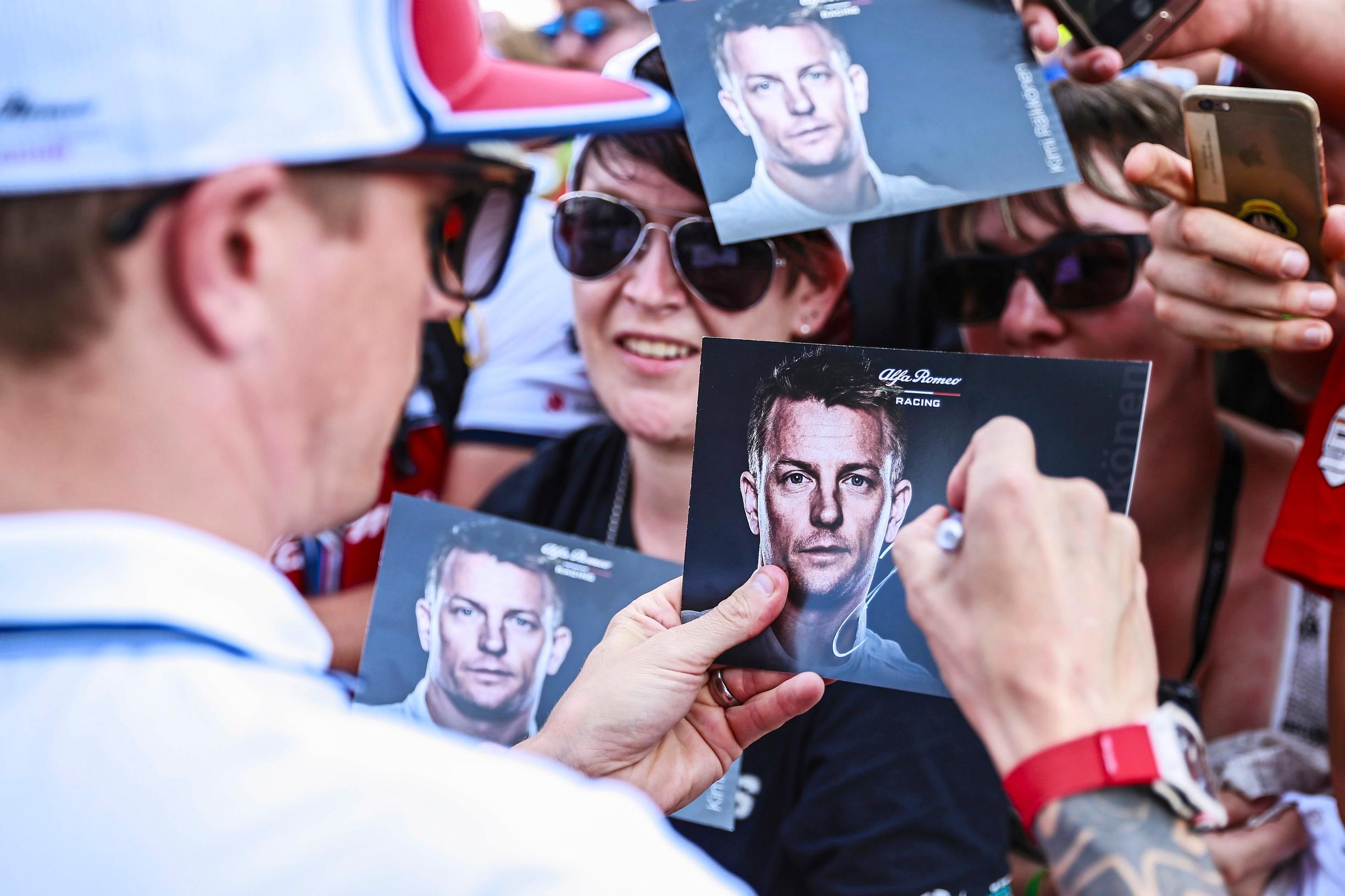 Kimi Räikkönen signeeraa fanikortteja Hockenheimissa.