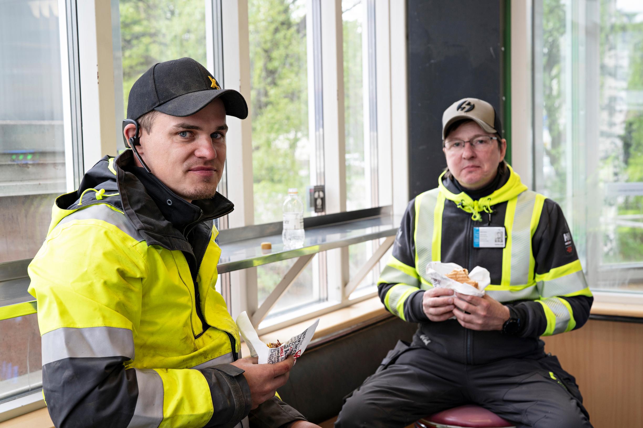 Oululainen Martti Häkkilä ja muhoslainen Jukka Greus istuvat grillillä hampurilaisella.