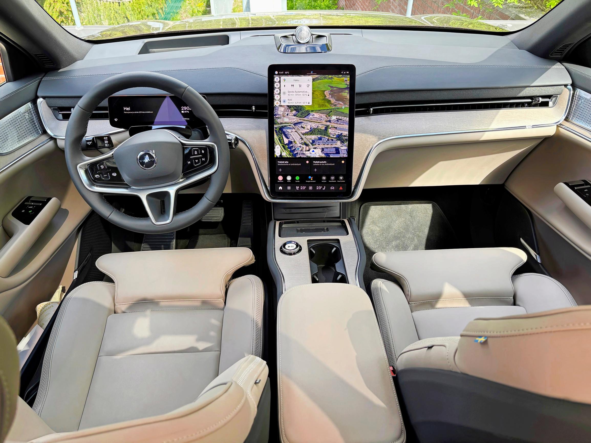 Volvo EX90:n ohjaamoilme miellyttää, mutta liikaa toimintoja on upotettu tietoviihdenäyttöön. Käytännössä vain äänenvoimakkuutta voi säätää fyysisestä kiertokytkimestä.