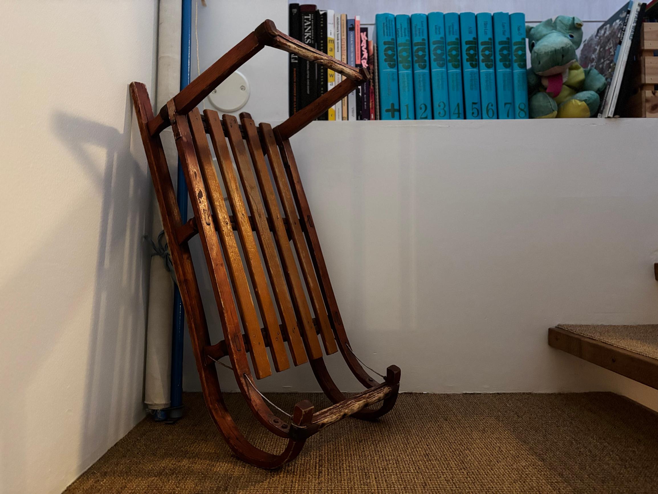 kelkka nojaamassa seinään, taustalla rivi kirjoja ja pehmolelu