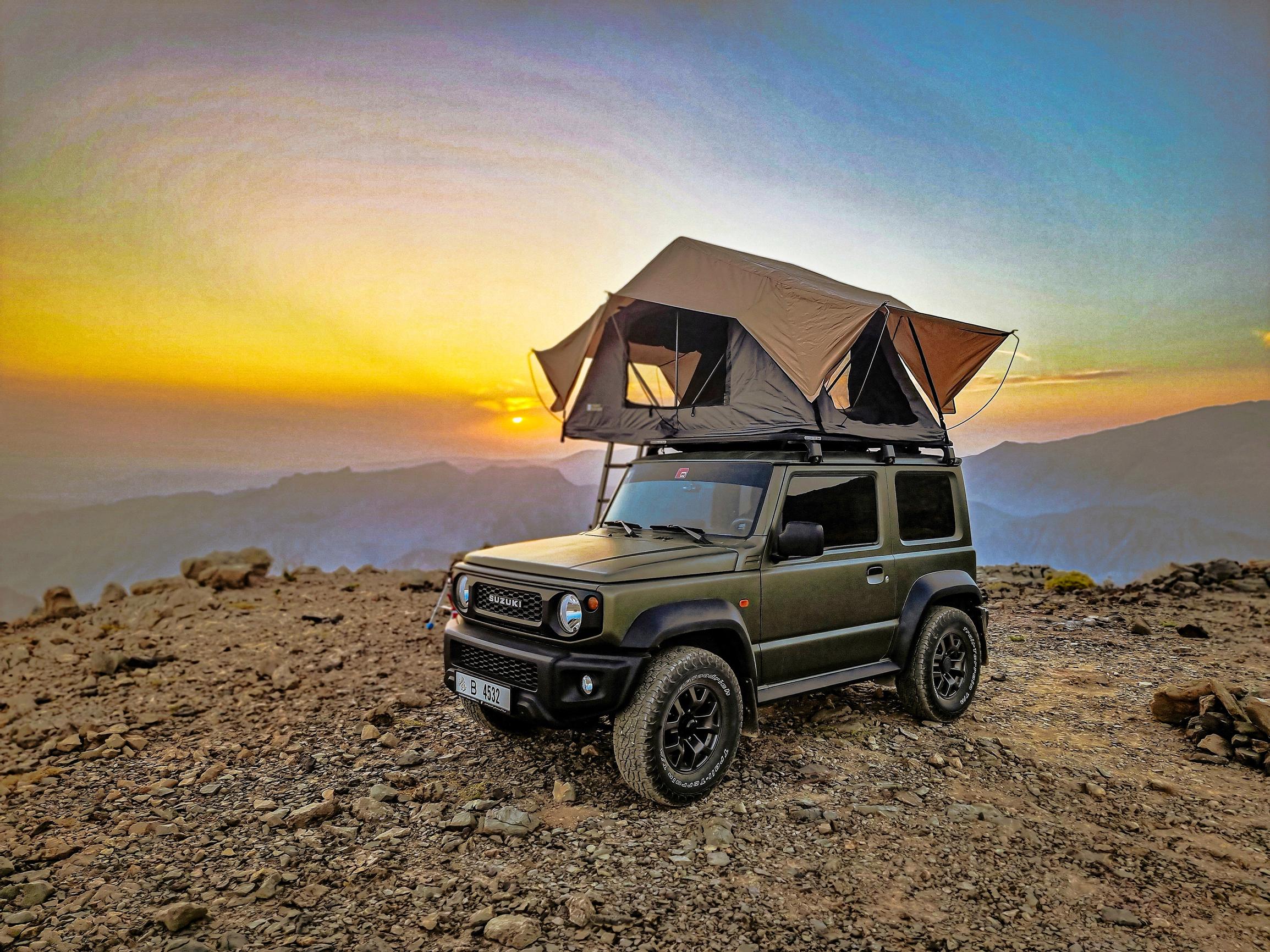 Suzuki Jimny. Piskuinen maasturi etenee pöpelikössä kuin näätä. Tässä versiossa on lisävarusteena kattoteltta.