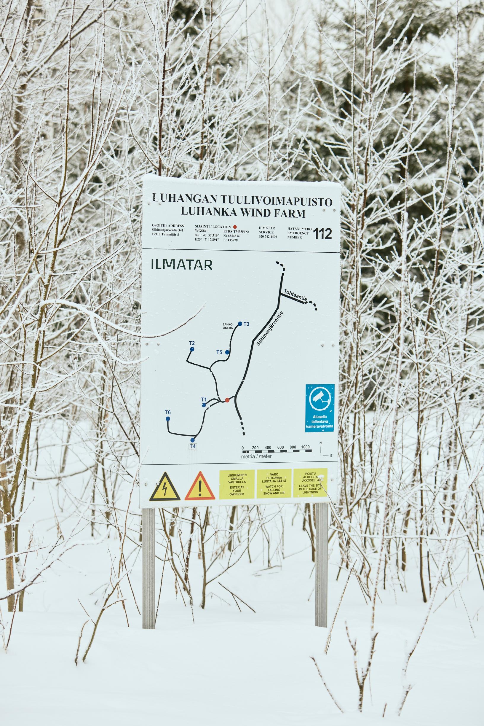 Tuulivoima-alueen reunalla kyltti varoittaa myös putoilevasta jäästä.