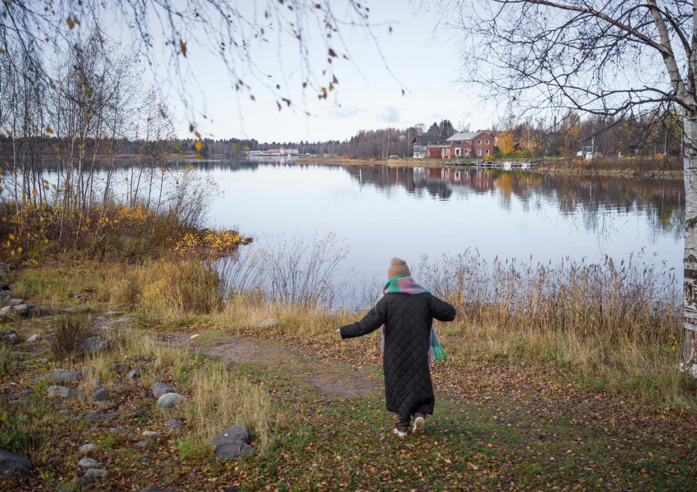 Ellinoora kävelee poispäin rannalla.