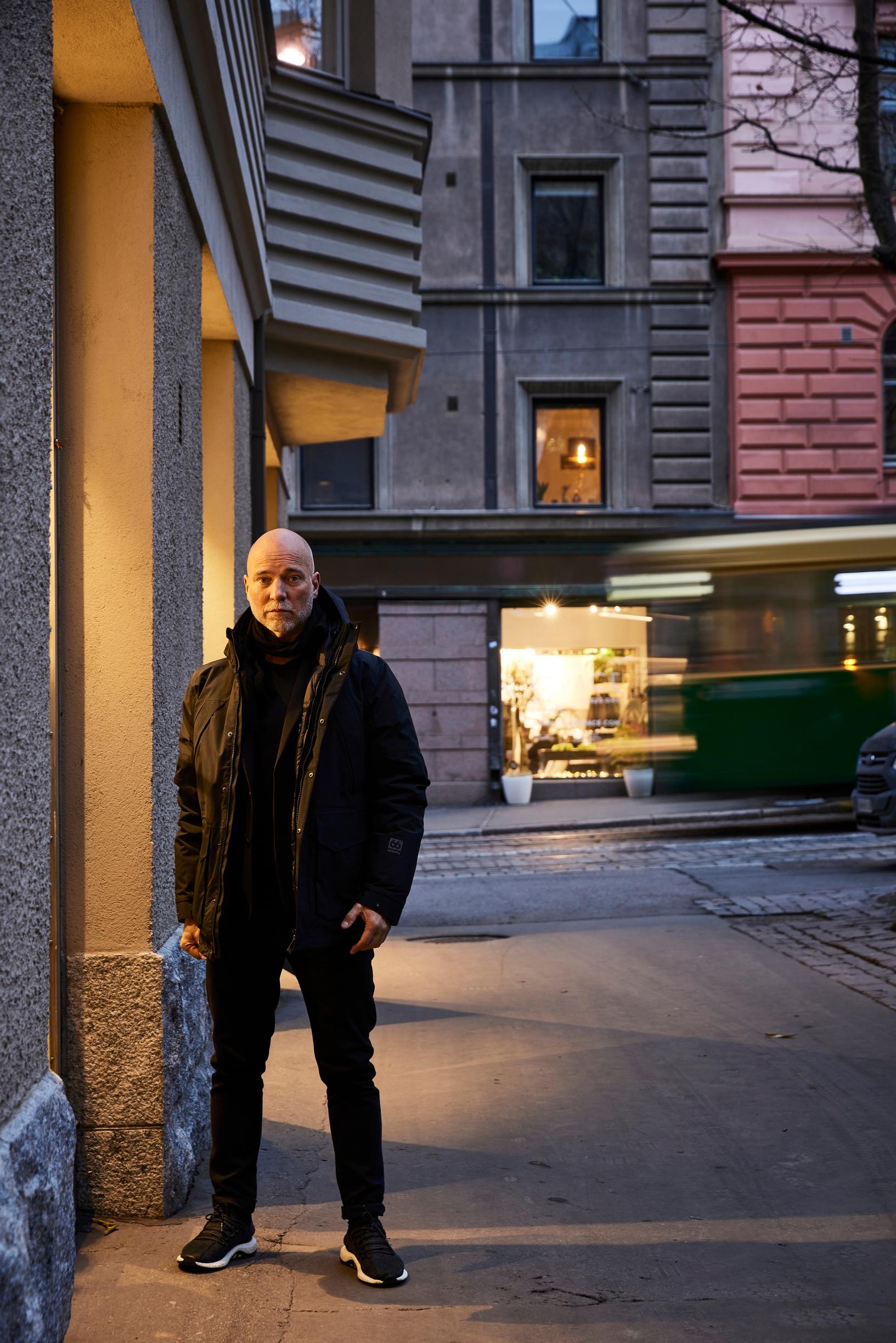 Aku Louhimies seisoo ulkona hämärässä.