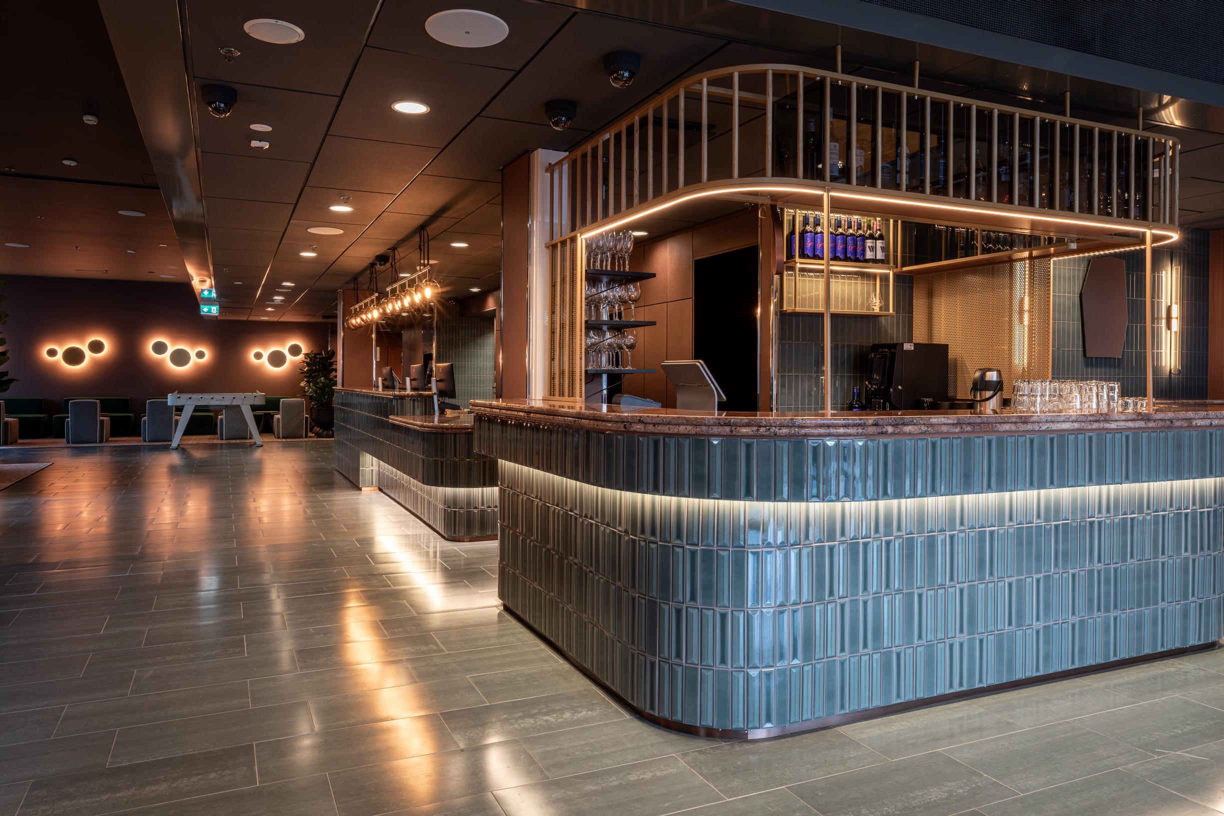 Scandic Helsinki Station -hotellin aula, josta löytyy respan lisäksi baari, oleskelutiloja ja työskentelypisteitä.