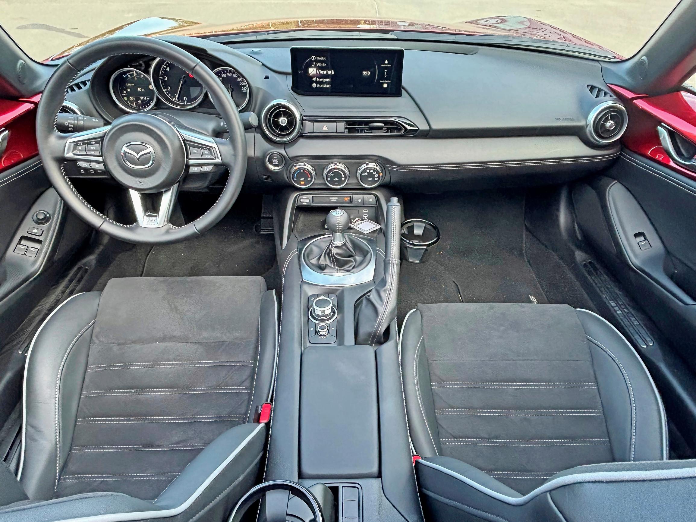 Mazda MX-5:n kyydissä asiat eivät ole hullummin, jos kyytiin vain mahtuu. Kytkimet ja säätimet ovat vanhan liiton mallia, mistä plussaa. Hansikaslokero on selän puolella kuskin ja vänkärin välissä.