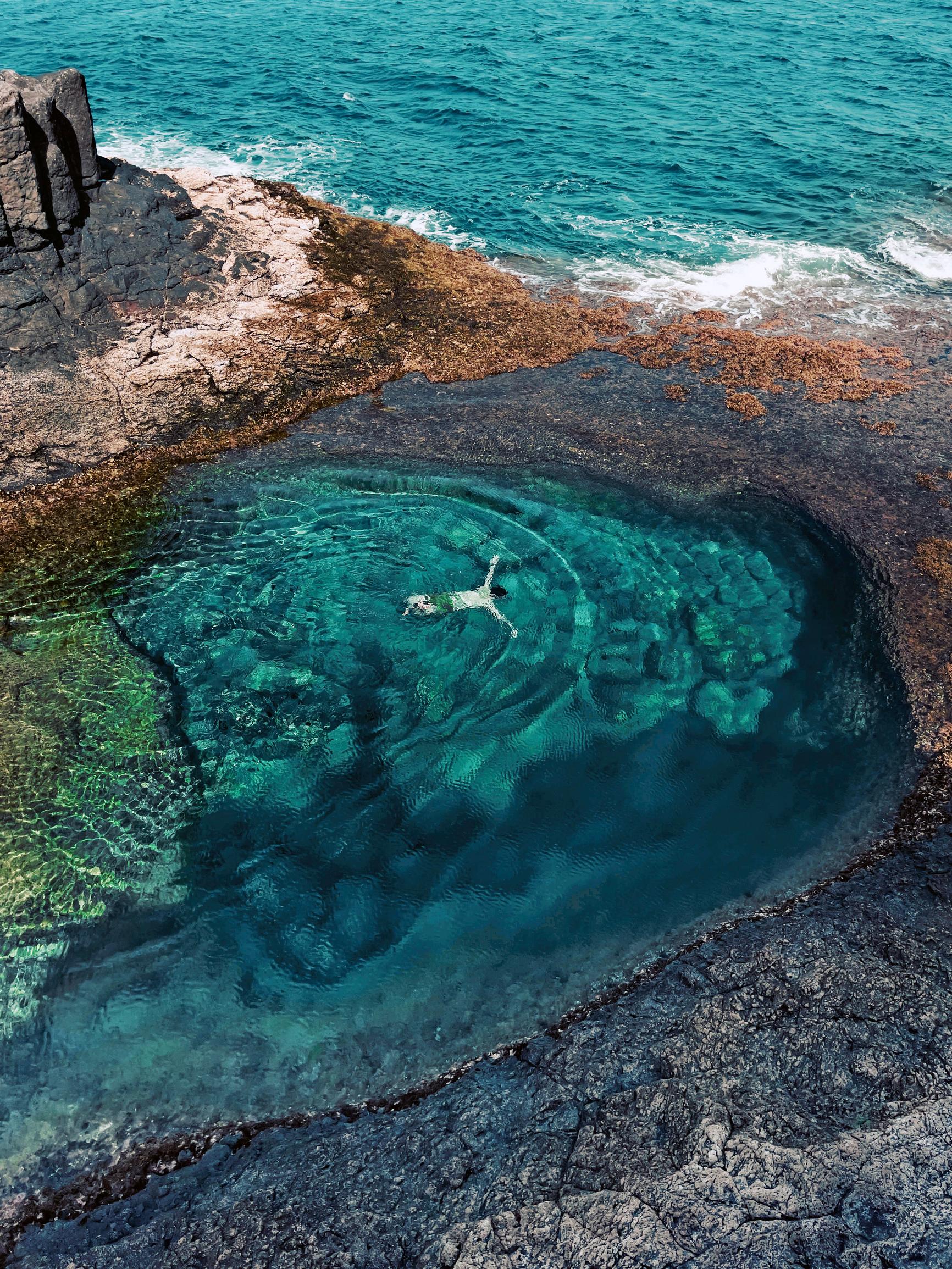 Luonnonallas Fuenteventuran Caleta de Fustessa, jossa on matkailijoiden suosima kaupunki hotelleineen sekä vanha linnoitustorni.