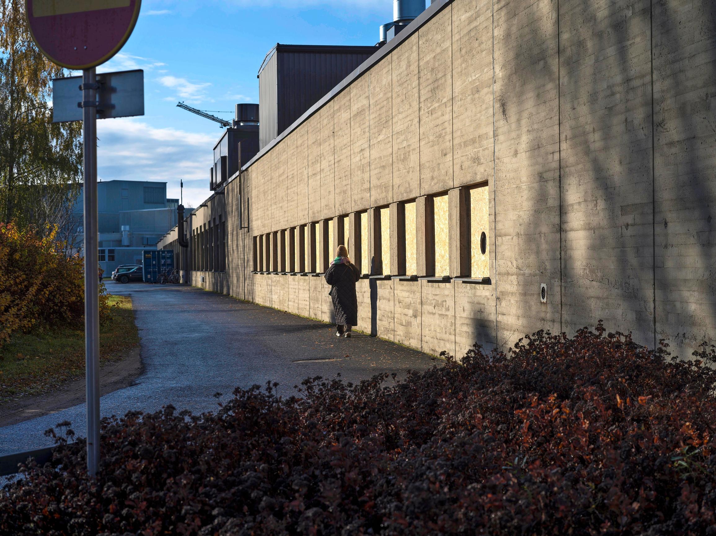 Ellinoora kulkee rakennuksen viertä.