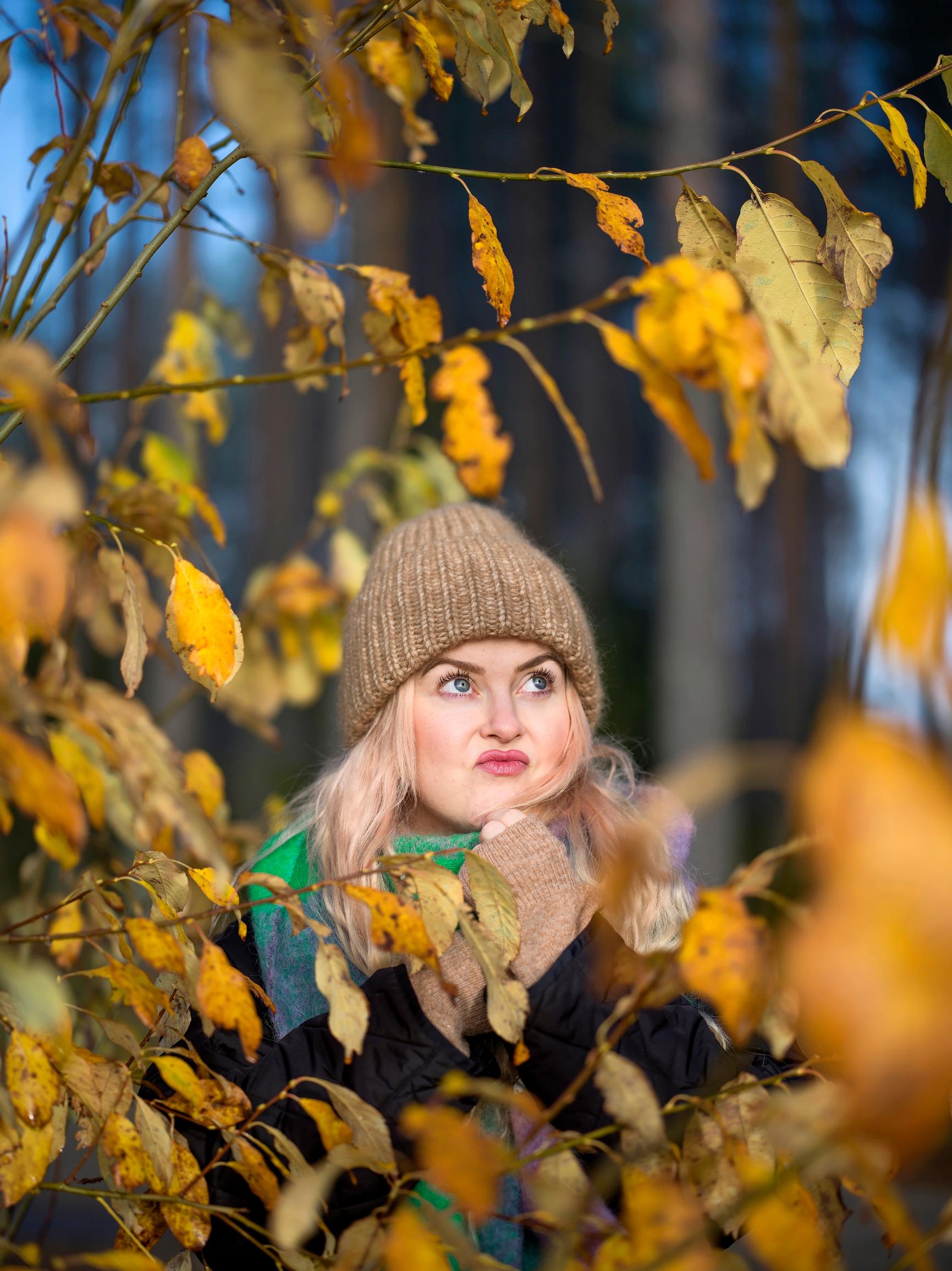 Ellinoora puiden välissä ruskan aikaan.